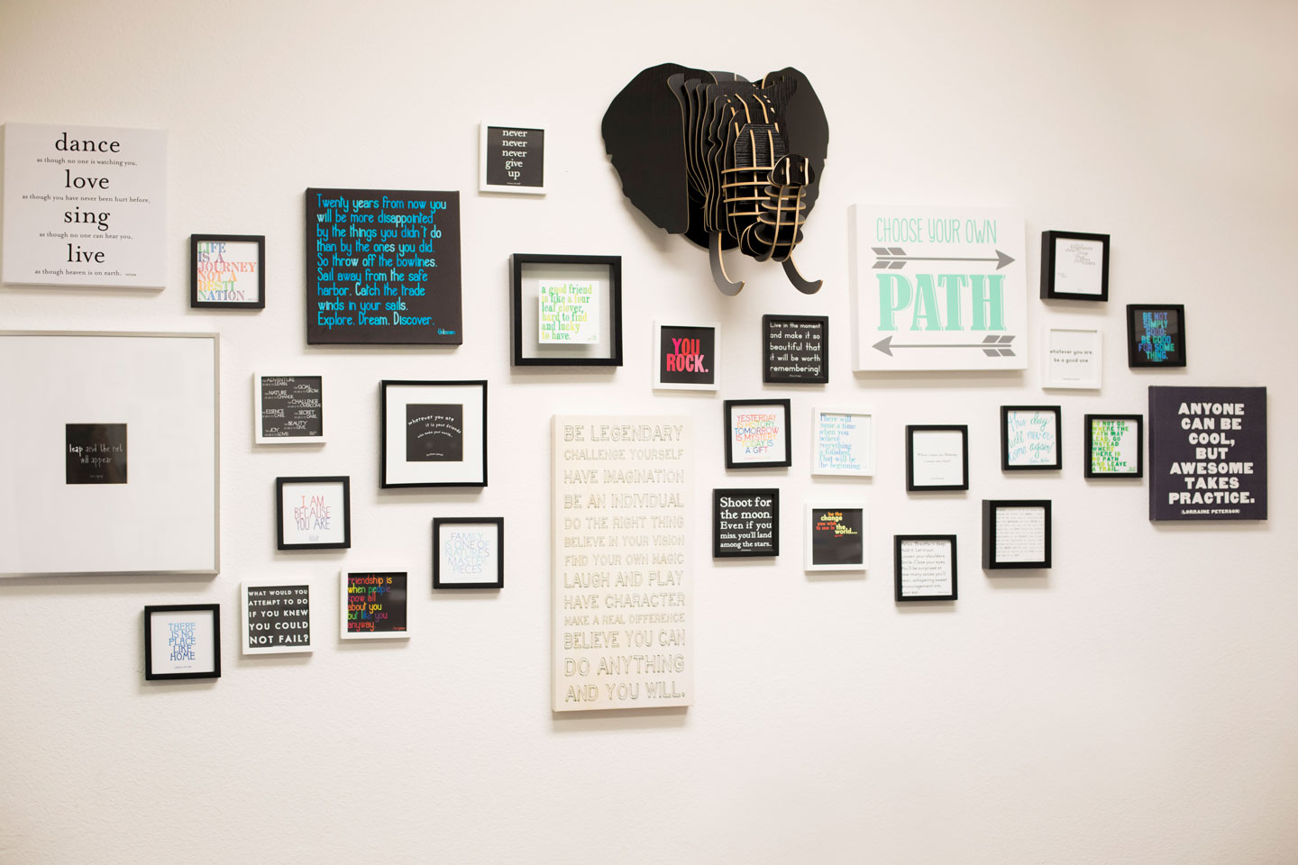 Image of a wall in the Smile Design Orthodontics practice. The wall has multiple pictures of motivational and funny slogans.