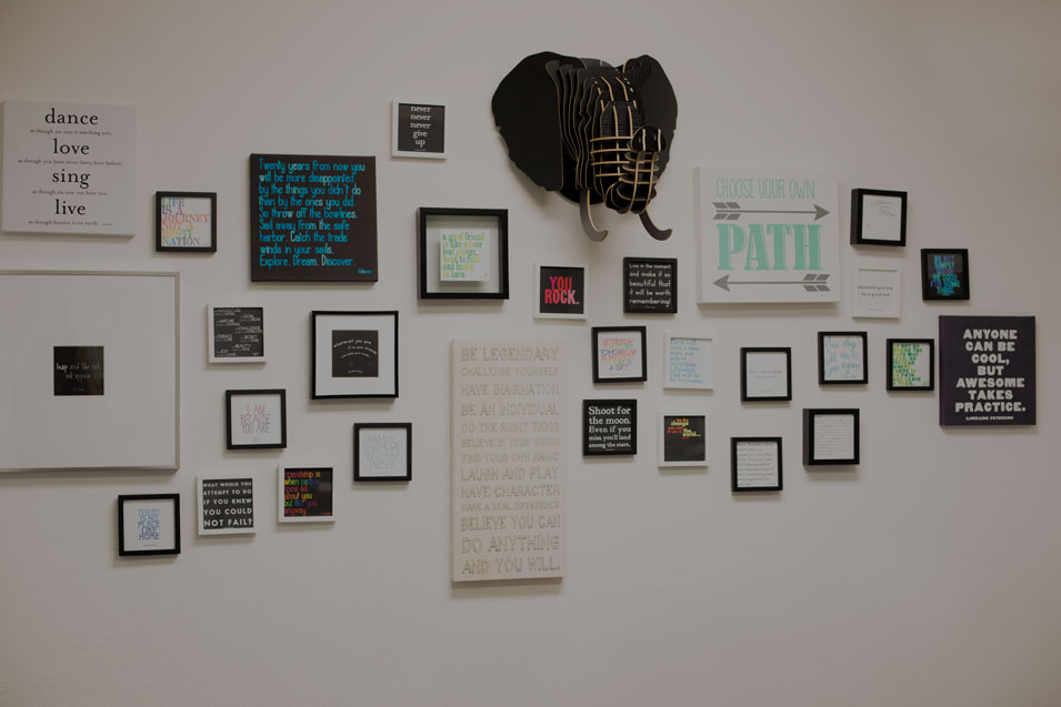 An image of a wall with framed pictures of inspirational quotes and phrases