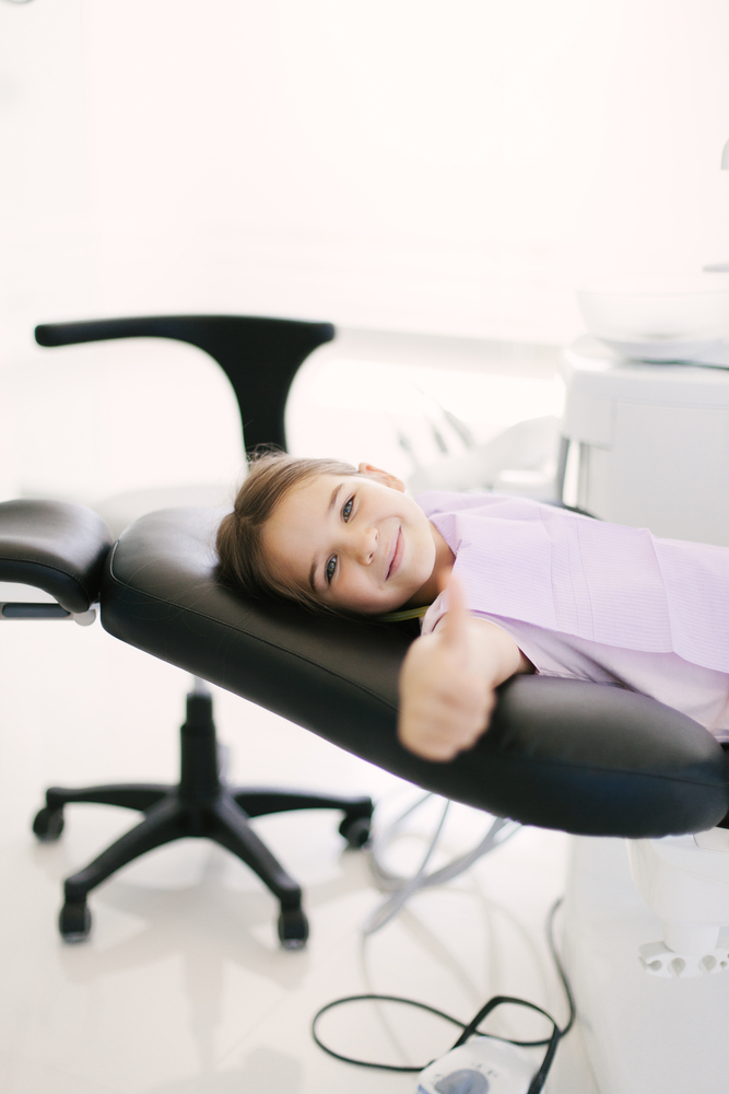 Happy girl lying on dentist chair